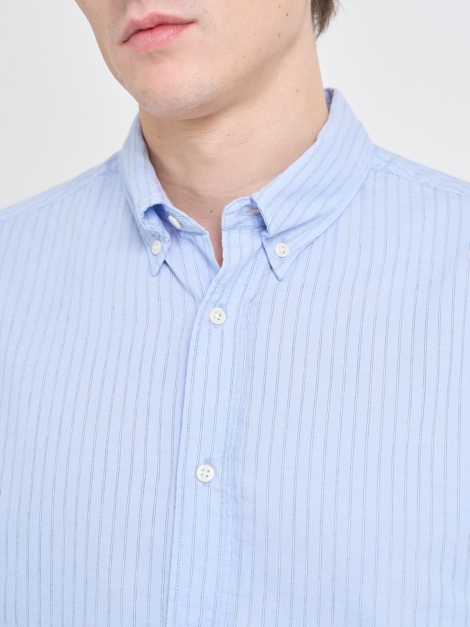 Close up collar shot of model wearing Oliver Spencer Men's Pale Blue Pinstripe Organic Cotton Button-Down Shirt