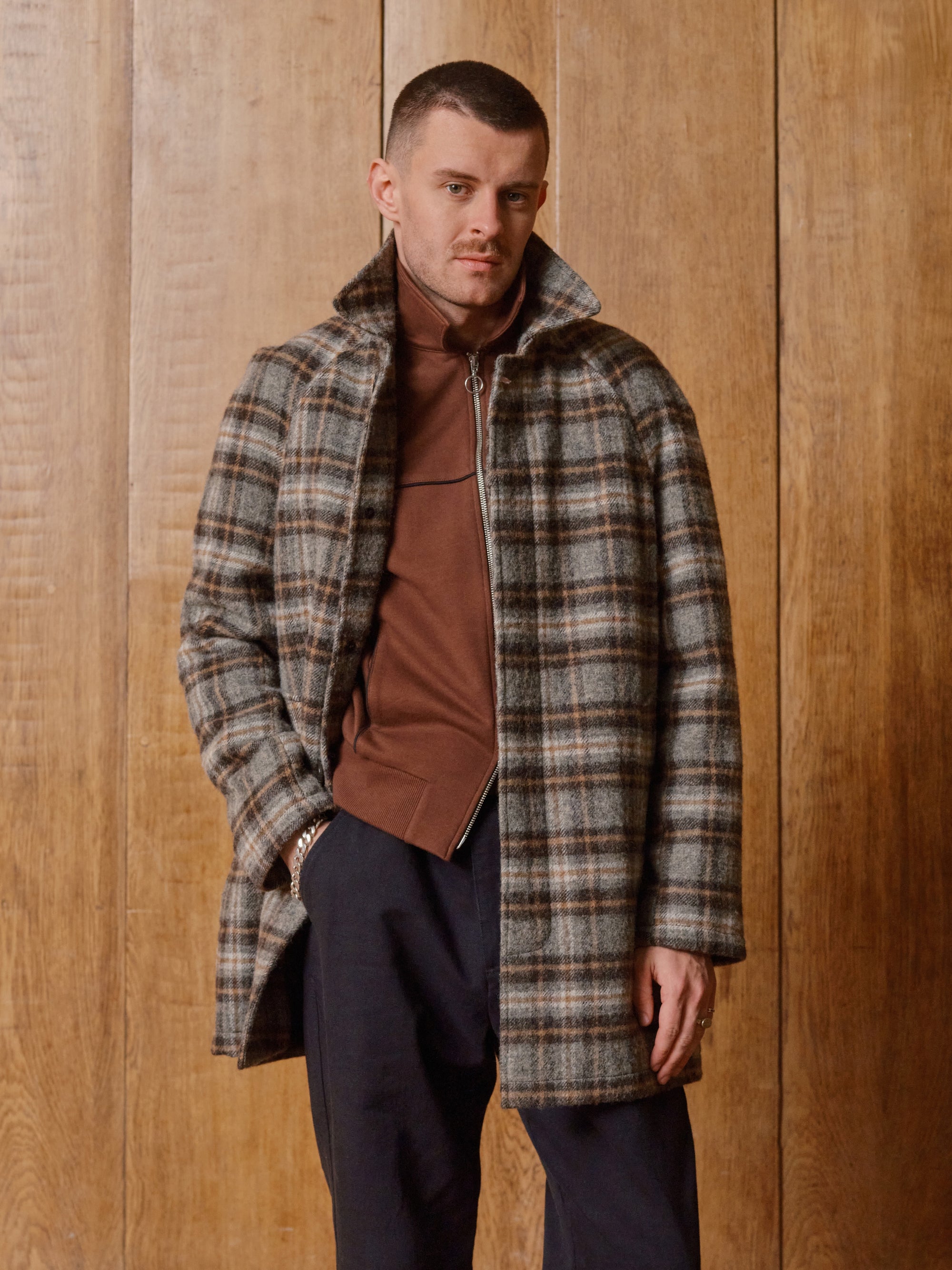 Model in a check coat and rust roll neck