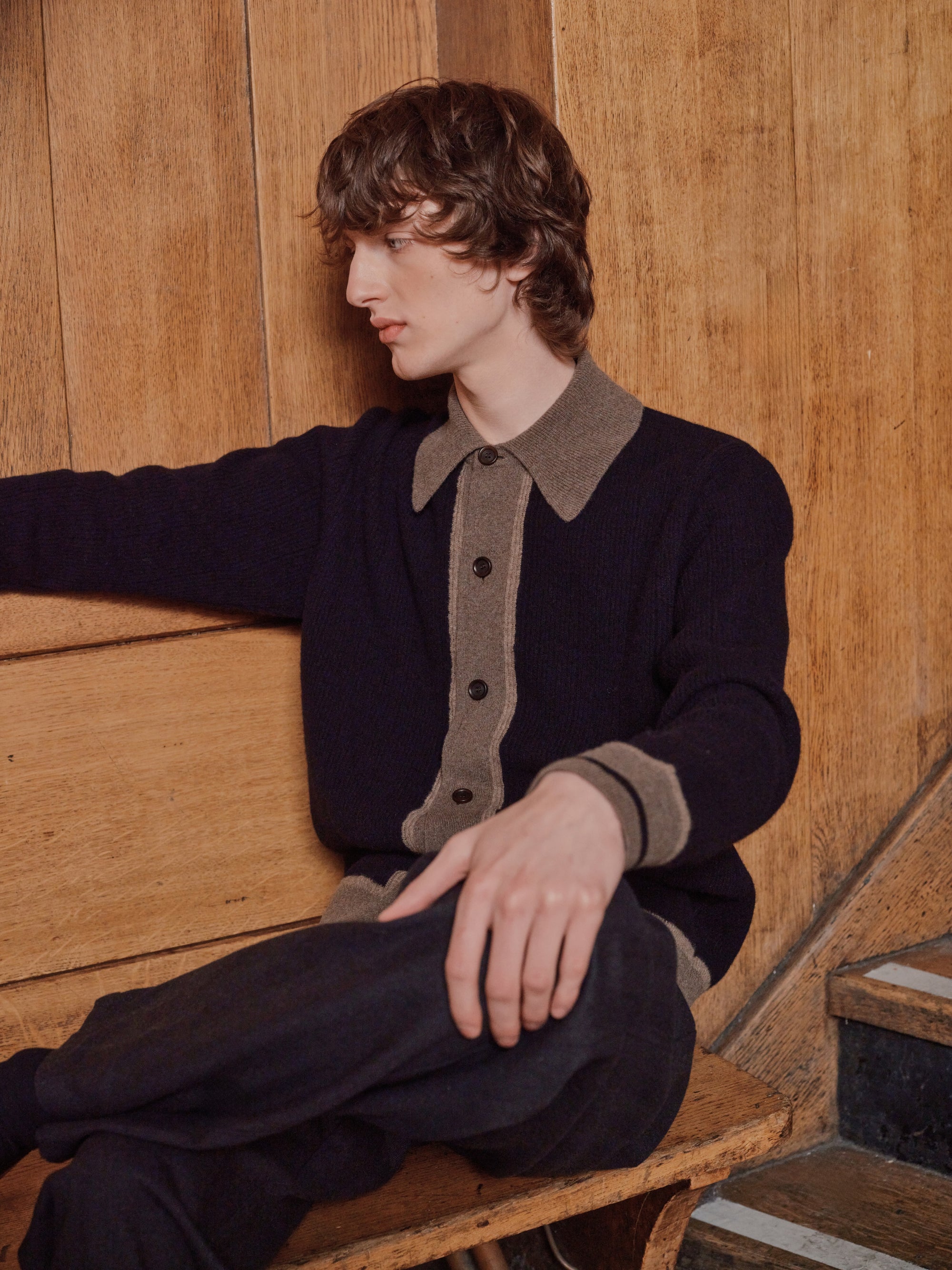 Model in a navy cardigan with a contrast collar, seated