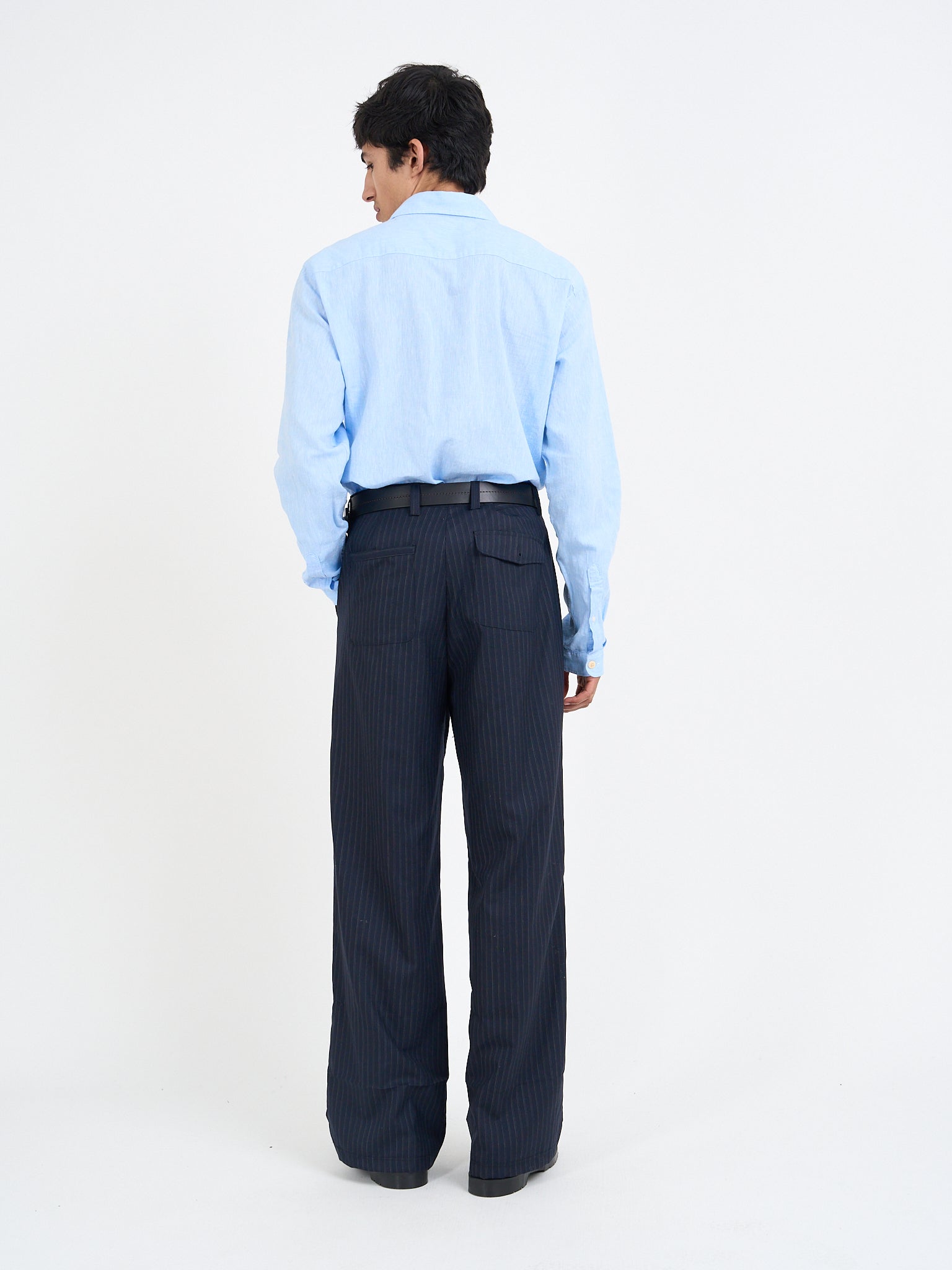 Orsman wide-leg navy pinstripe wool trousers worn on model, rear view