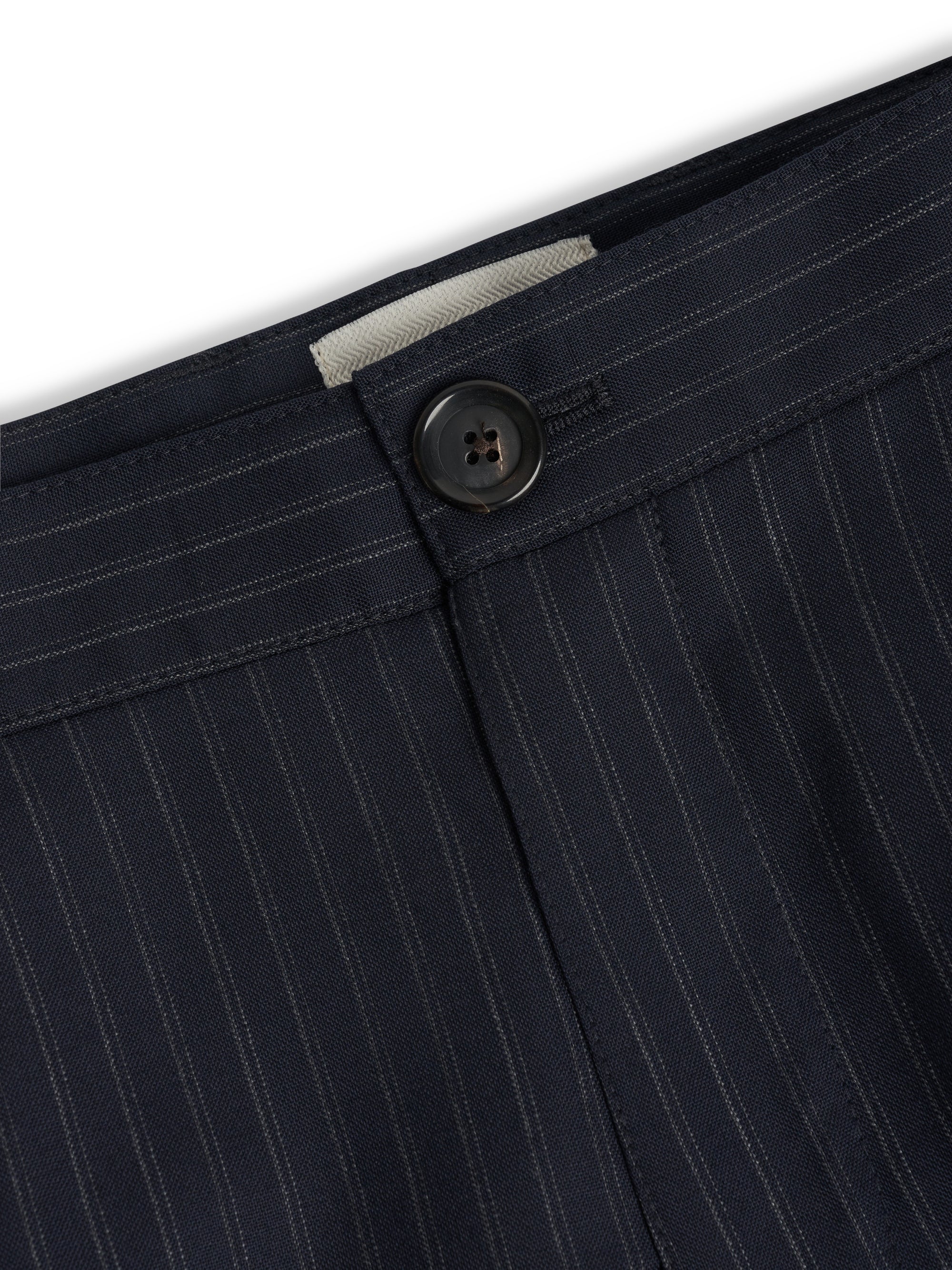 Orsman trousers in navy pinstripe wool showing single pleat and waistband detail